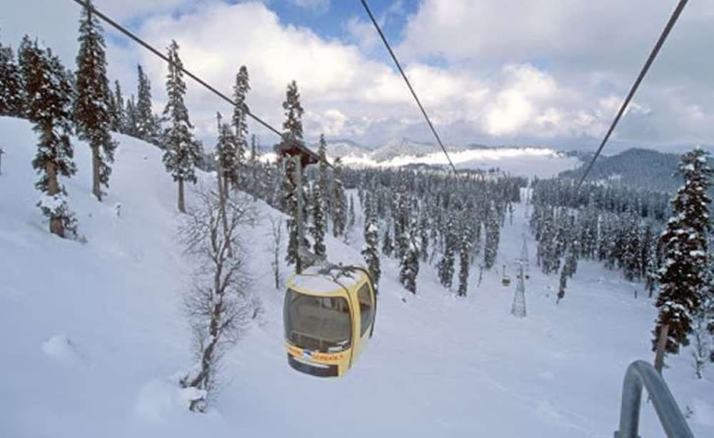 The Gulmarg gondola climbing over snow-laden pines in winter
